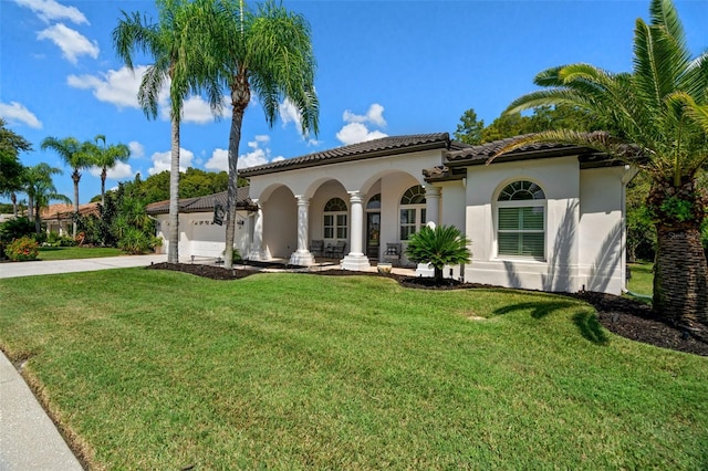 mediterranean / spanish-style home featuring a garage and a front yard