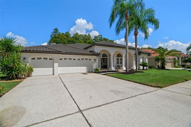 mediterranean / spanish-style house featuring a garage and a front yard