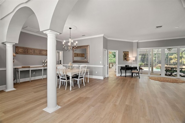 dining space featuring ornate columns, crown molding, a healthy amount of sunlight, and light hardwood / wood-style floors