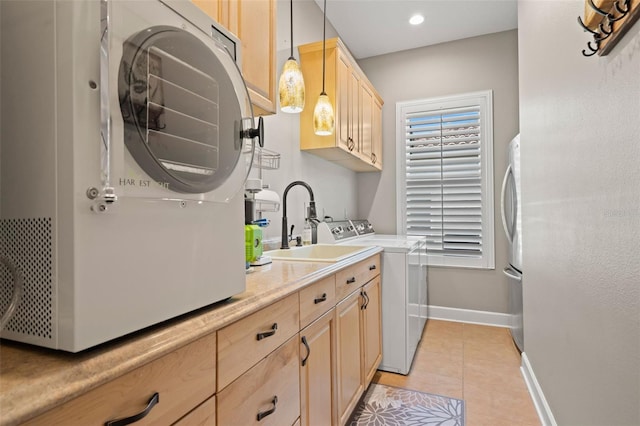 kitchen with light tile patterned flooring, decorative light fixtures, separate washer and dryer, sink, and light brown cabinets