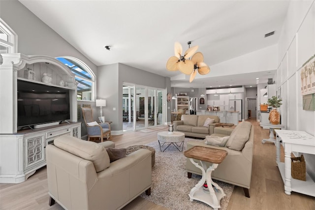 living room featuring lofted ceiling and light hardwood / wood-style floors