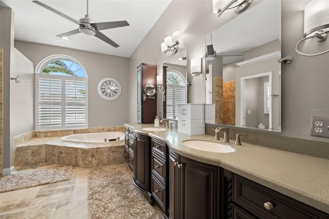 bathroom featuring vanity, tiled bath, and ceiling fan