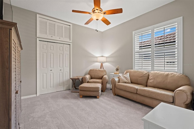 carpeted living room with ceiling fan