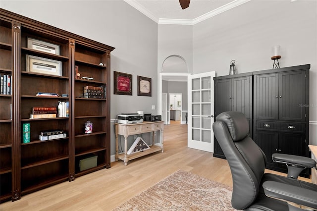 home office featuring crown molding, light hardwood / wood-style floors, french doors, and a high ceiling