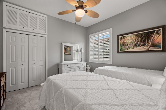 bedroom featuring light colored carpet, a closet, and ceiling fan