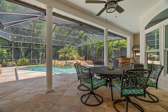 view of patio / terrace featuring a swimming pool with hot tub, ceiling fan, an outdoor fireplace, and glass enclosure