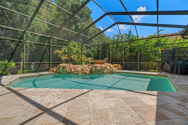 view of pool with grilling area, a lanai, and a patio area