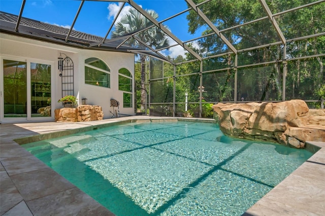 view of pool featuring glass enclosure and a patio area