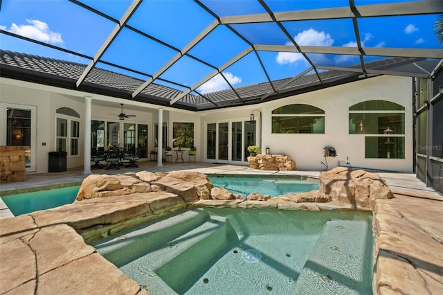 back of house with ceiling fan, a lanai, a pool with hot tub, and a patio