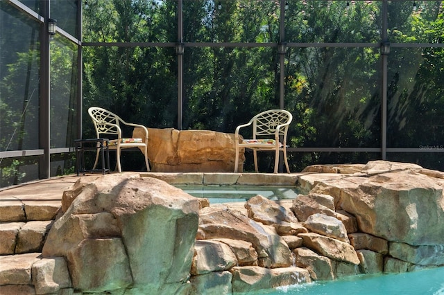 view of swimming pool featuring an in ground hot tub and glass enclosure