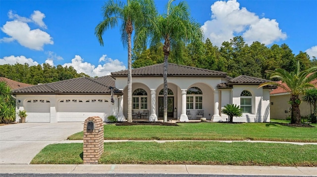 mediterranean / spanish-style home with a garage and a front yard