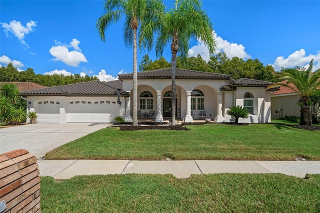 mediterranean / spanish home featuring a garage and a front lawn