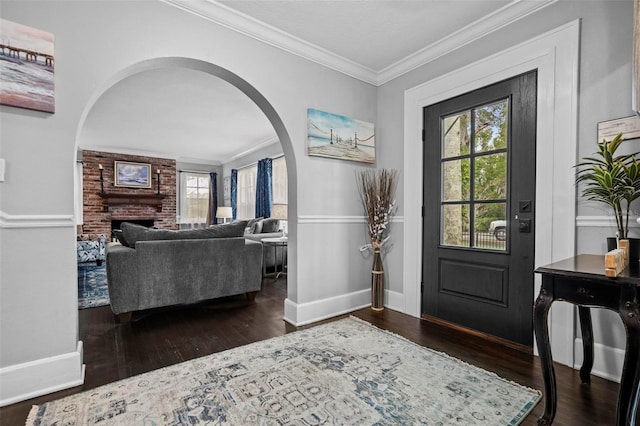 entrance foyer featuring crown molding, dark hardwood / wood-style floors, and a brick fireplace