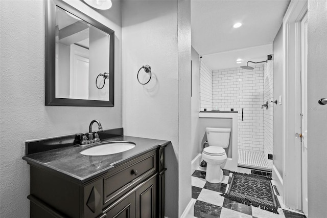 bathroom featuring vanity, tiled shower, and toilet