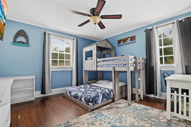 bedroom with dark hardwood / wood-style flooring, crown molding, and ceiling fan