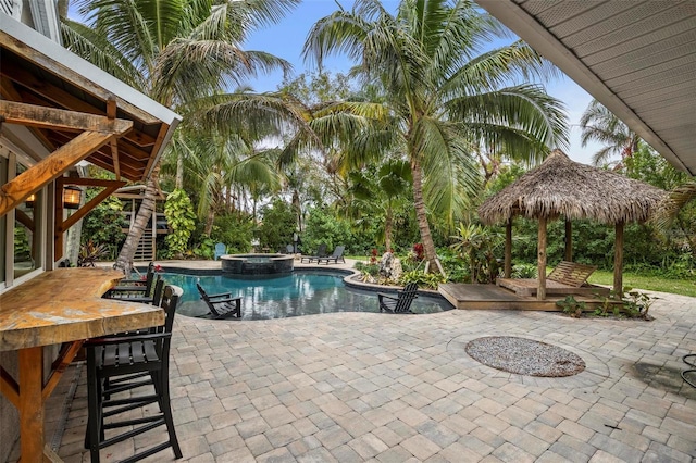 view of pool with a patio, a gazebo, an outdoor bar, and an in ground hot tub