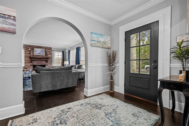 319 26th St W, Bradenton, FL 34205 - entryway with arched walkways, ornamental molding, wood finished floors, baseboards, and a brick fireplace
