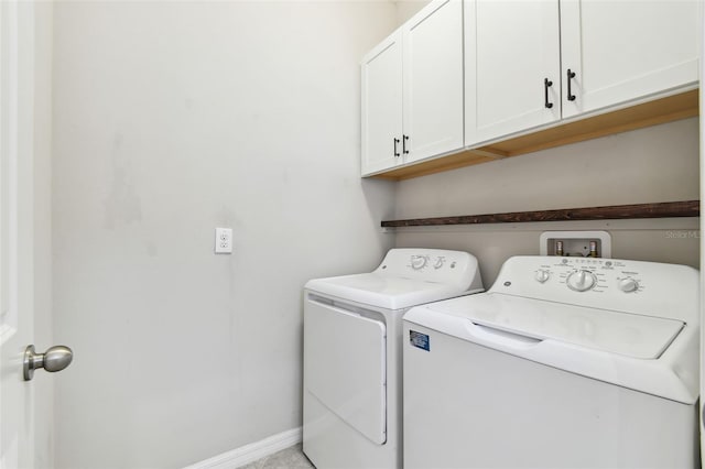 washroom featuring cabinets and washer and clothes dryer