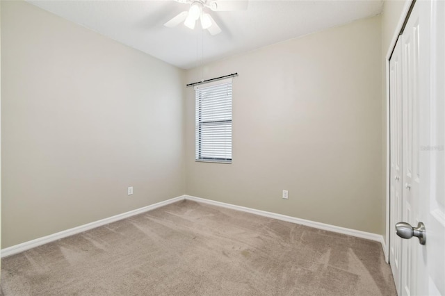 spare room with ceiling fan and light colored carpet