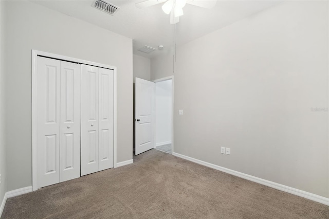 unfurnished bedroom featuring ceiling fan, a closet, and light carpet