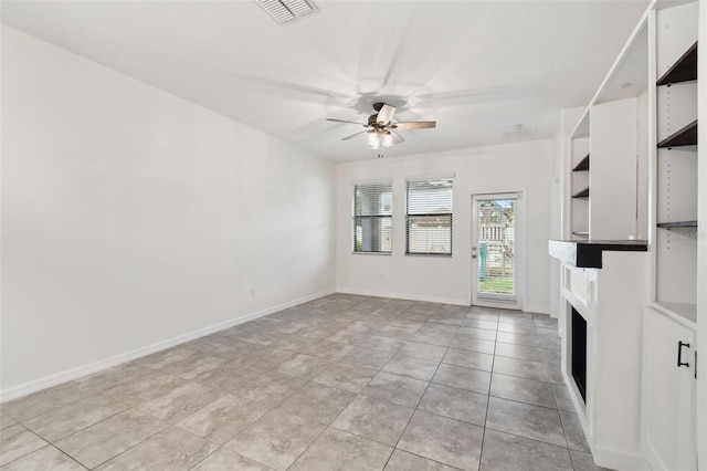 unfurnished living room featuring light tile patterned floors and ceiling fan