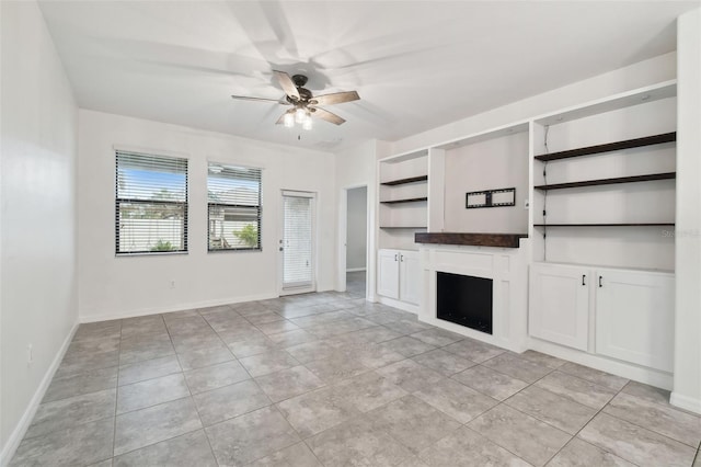 unfurnished living room with light tile patterned floors, built in shelves, and ceiling fan