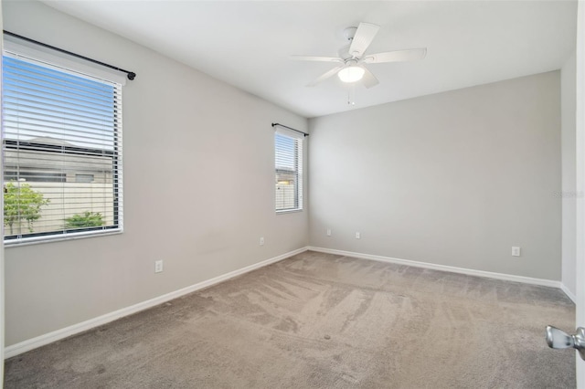 carpeted spare room featuring ceiling fan