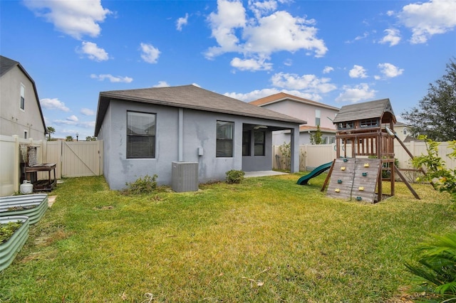 back of house with a playground, a yard, and cooling unit