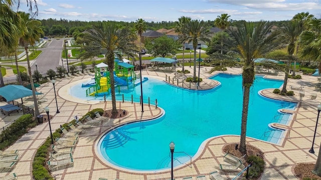 view of pool featuring a playground, a patio, and a water slide