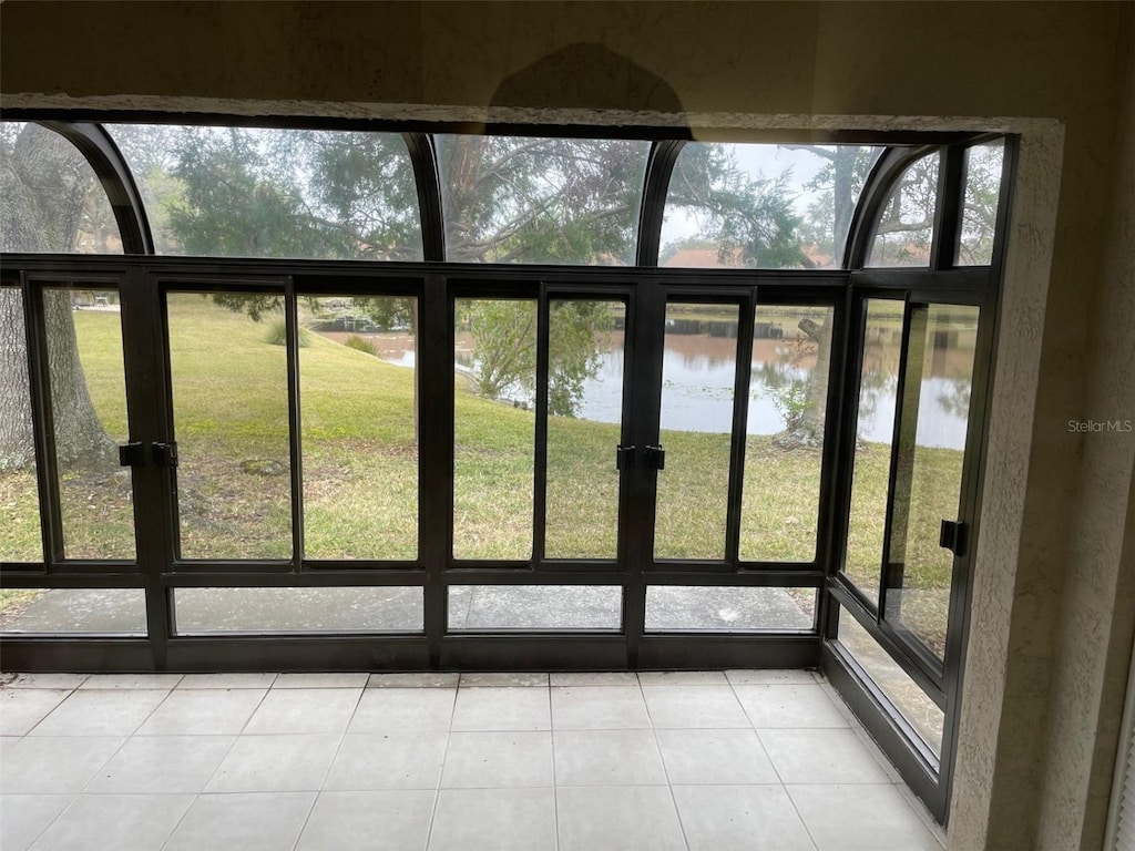 interior space with a water view and light tile patterned flooring