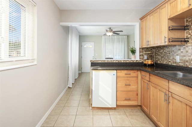 kitchen with backsplash, kitchen peninsula, ceiling fan, and light tile patterned flooring