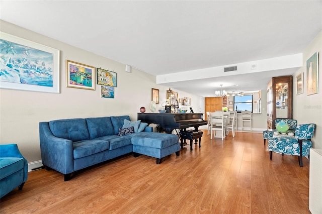 living room with a chandelier and light hardwood / wood-style floors