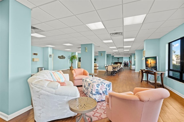 living room featuring a drop ceiling and hardwood / wood-style floors