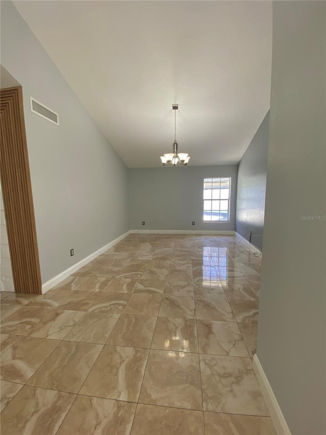 spare room with an inviting chandelier and vaulted ceiling