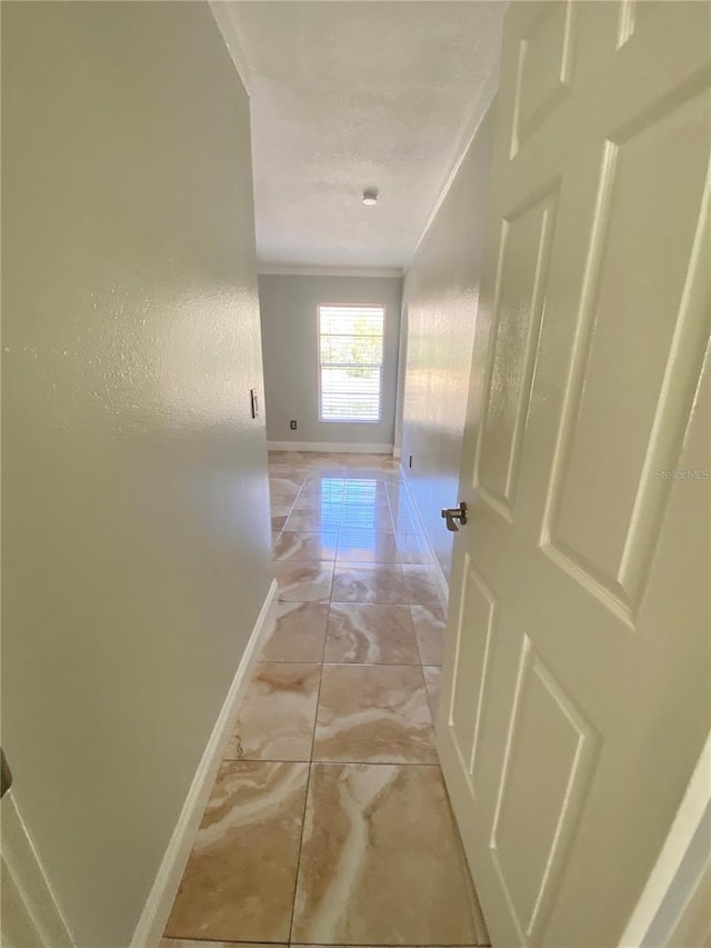 hall featuring ornamental molding and a textured ceiling