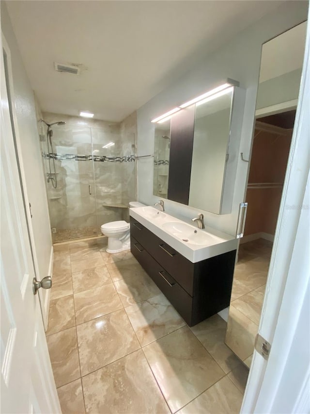 bathroom featuring vanity, a shower with door, and toilet