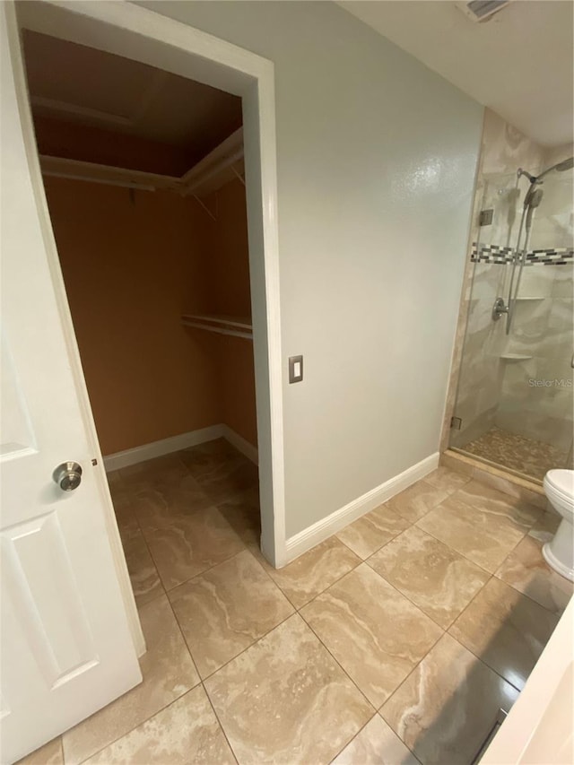 bathroom featuring toilet and walk in shower