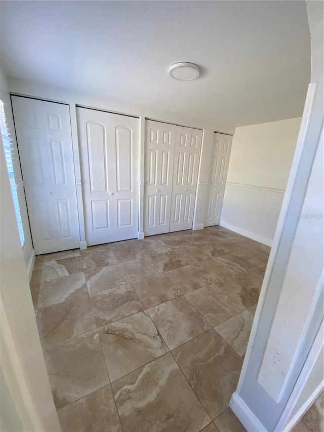 unfurnished bedroom with two closets