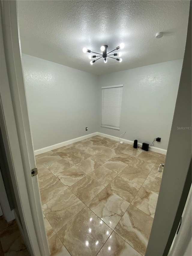 laundry area with an inviting chandelier and a textured ceiling