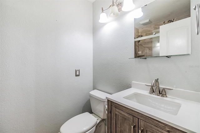 bathroom featuring vanity, an enclosed shower, and toilet