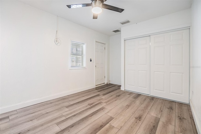 unfurnished bedroom featuring ceiling fan, light hardwood / wood-style floors, and a closet