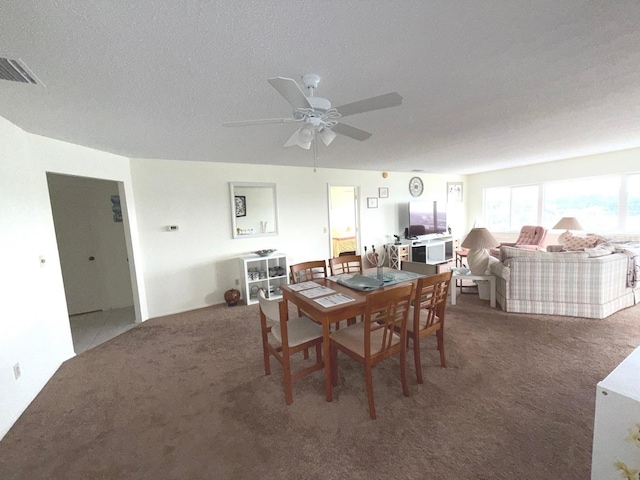 dining area featuring ceiling fan, a textured ceiling, and carpet