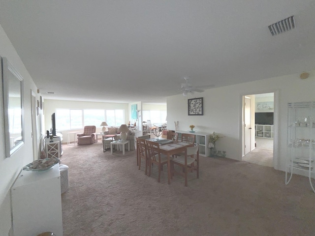 dining space featuring carpet floors and ceiling fan