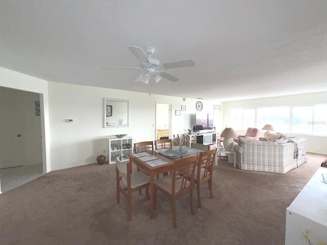 carpeted dining space featuring a textured ceiling and ceiling fan