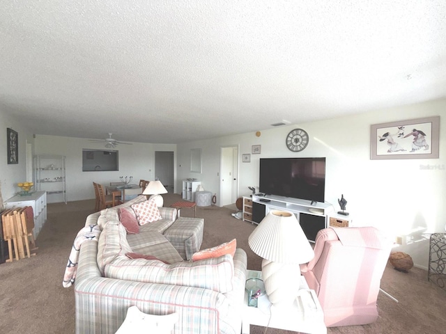 living room with ceiling fan, carpet floors, and a textured ceiling