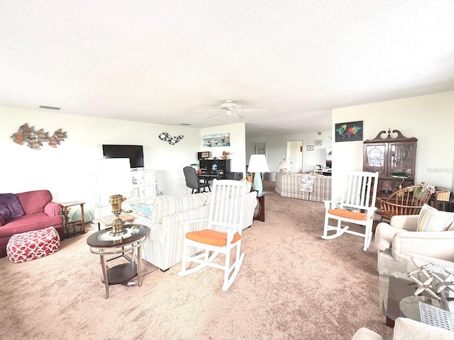 carpeted living room with ceiling fan and a textured ceiling