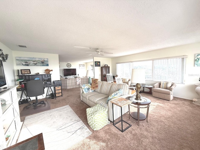 living room featuring carpet floors, a textured ceiling, and ceiling fan