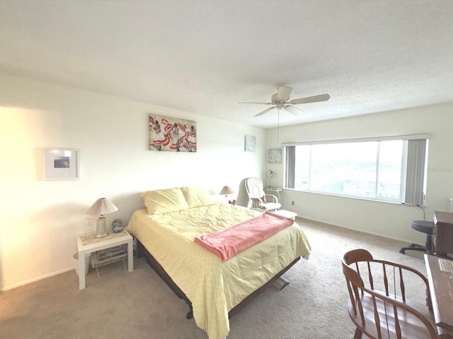 carpeted bedroom with ceiling fan and a textured ceiling