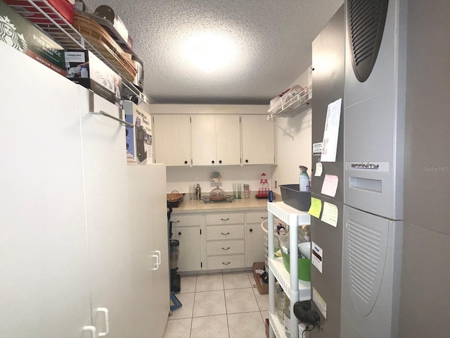 kitchen with a textured ceiling and light tile patterned flooring