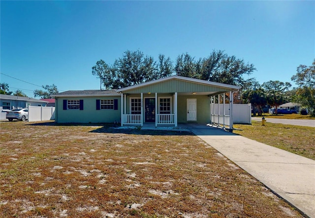 view of front of home with a carport, covered porch, and a front lawn